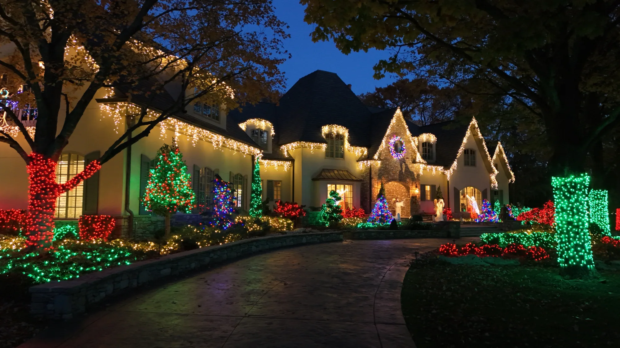 Warm white eaves with red and green trees. Christmas Lighting by LIT Outdoor Lighting in Tulsa.