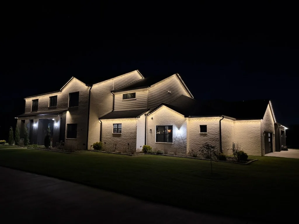 Stone home roofline in warm white. Permanent Lighting by LIT Outdoor Lighting in Tulsa.