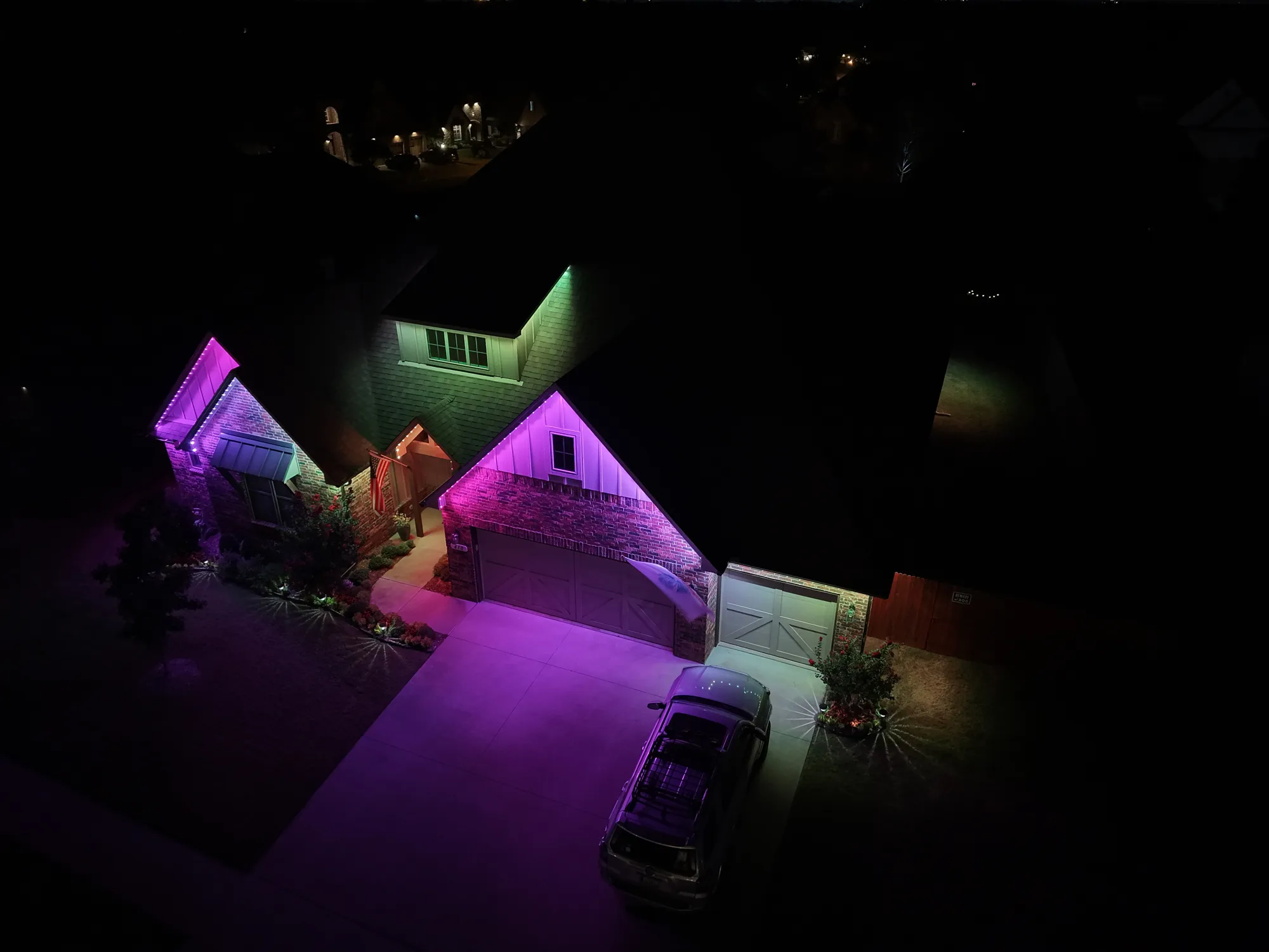 Aerial of gables lit in purple and green. Permanent Lighting by LIT Outdoor Lighting in Tulsa.