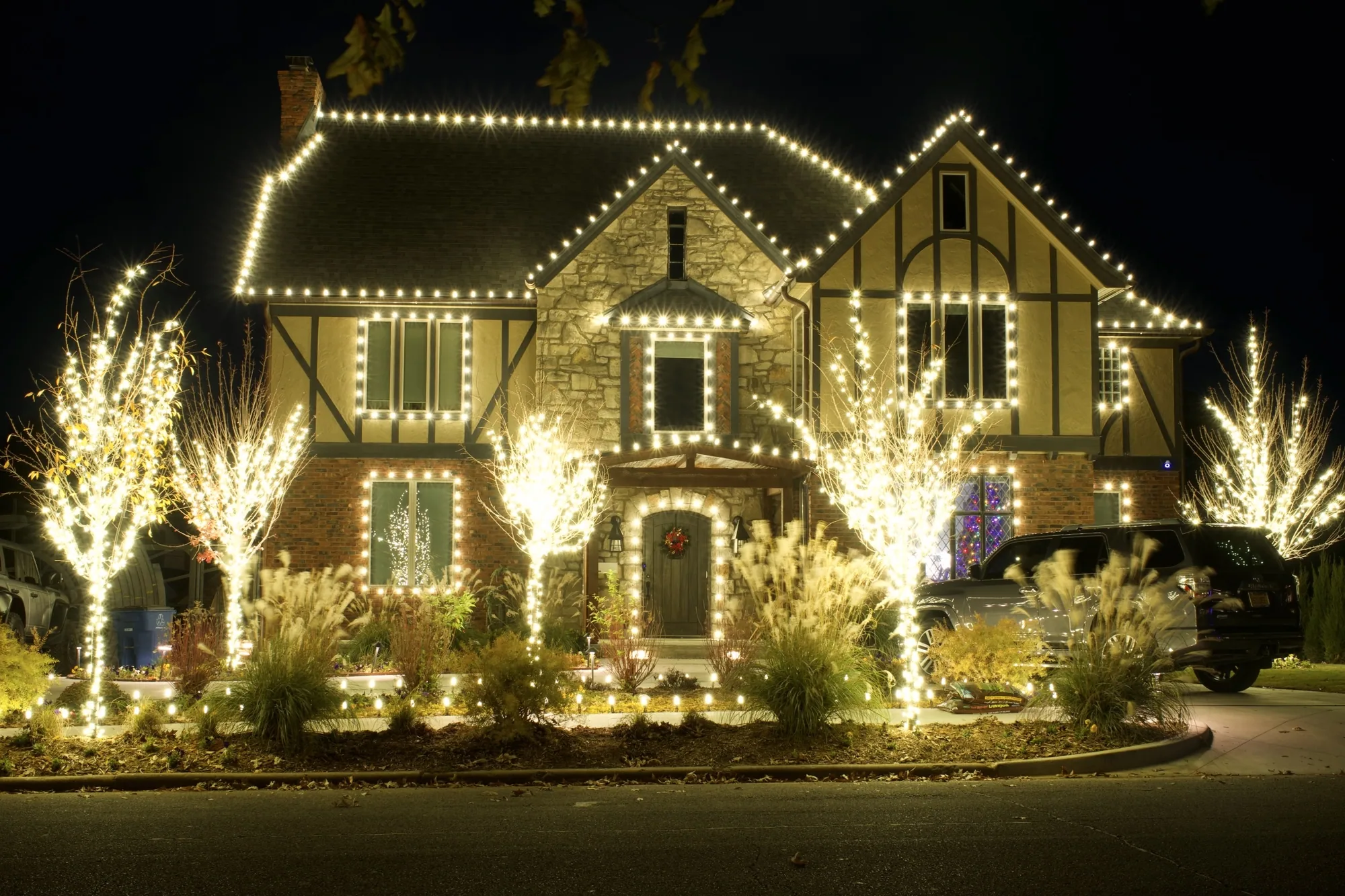Tudor front in warm white with the trees wrapped. Christmas Lighting by LIT Outdoor Lighting in Tulsa.