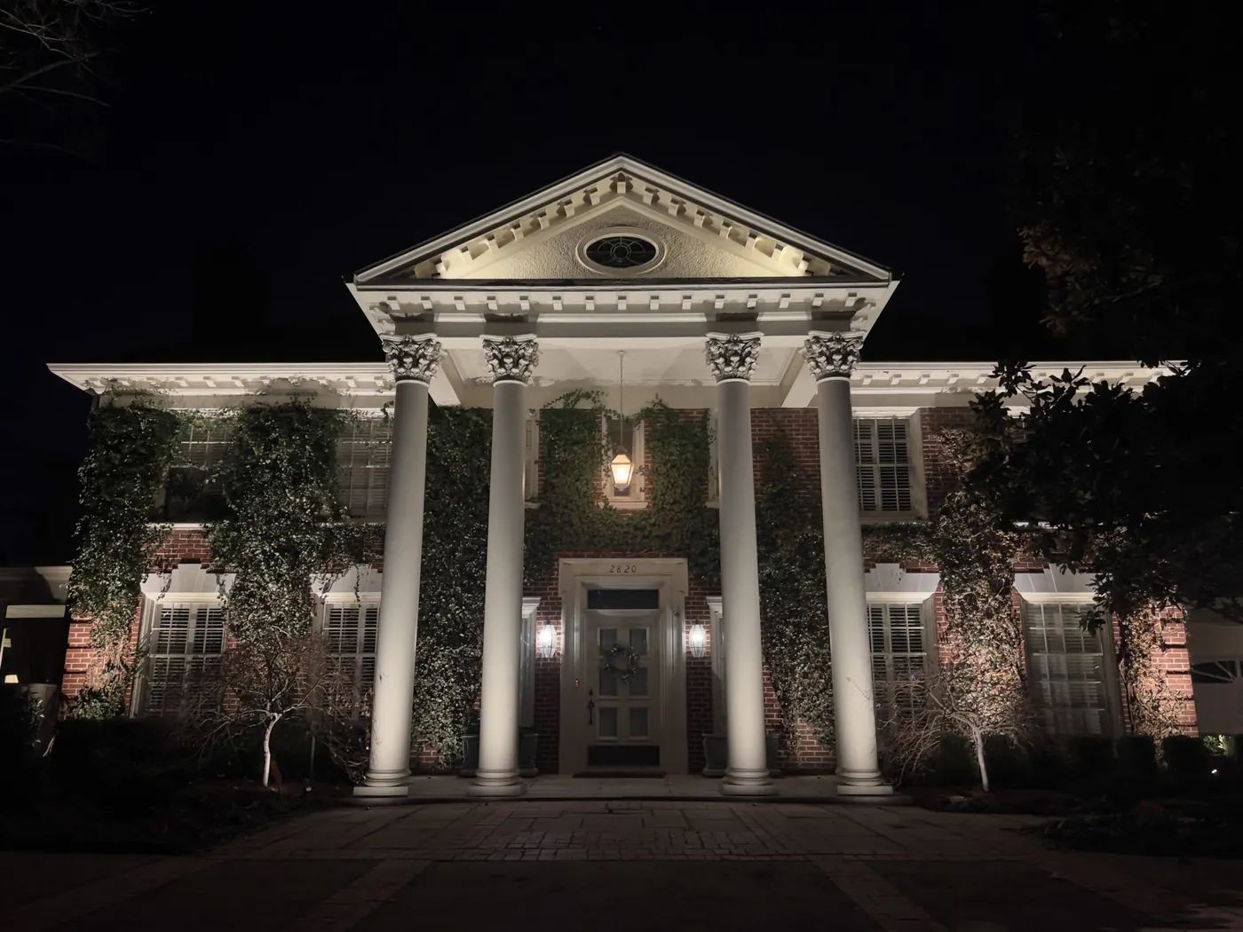 A columned facade washed white. Landscape Lighting by LIT Outdoor Lighting in Tulsa.